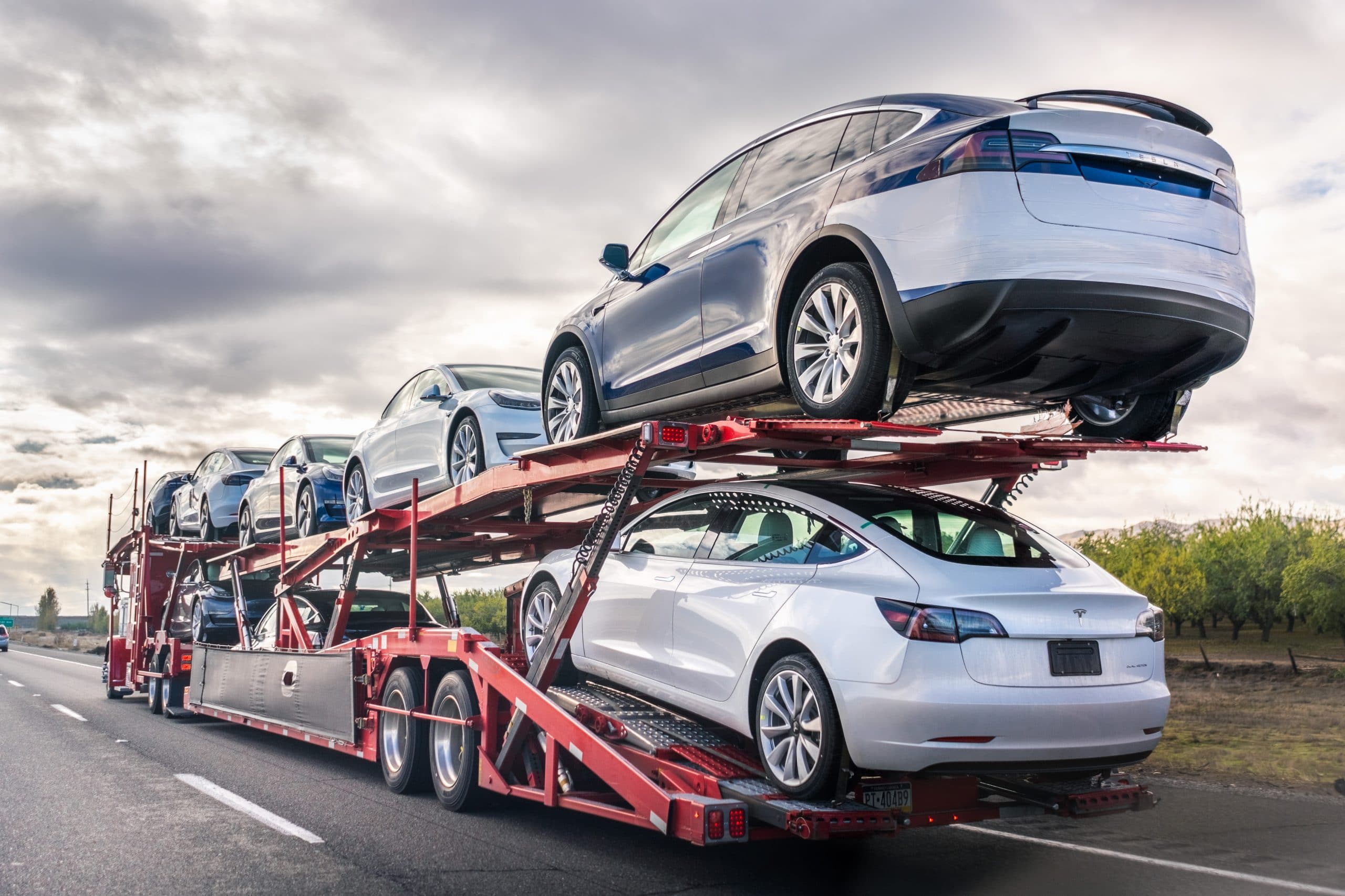 Dec 8, 2019 Bakersfield / CA / USA - Car transporter carries new Tesla vehicles along the interstate to South California, back view of the trailer